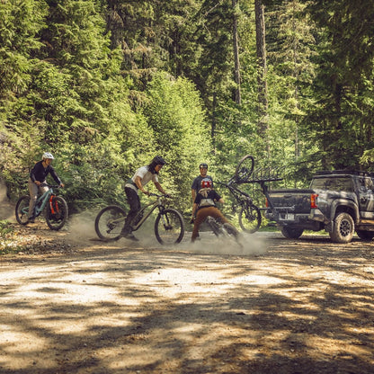 Pickup with hitch bike rack carrying bikes outdoors on a gravel road