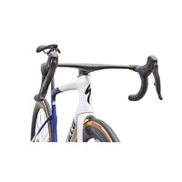 Road bike cockpit close-up with white-and-blue frame and black bar and controls