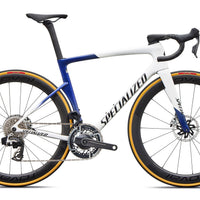 White and blue road bicycle with disc brakes, aero handlebars, and gold-rim wheels