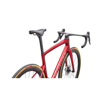 Red road bike close-up with black saddle, handlebar, and front wheel detail