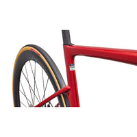 Red bike frame close-up with front wheel and gold-trim tire edge