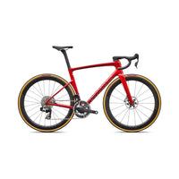 Red road bike with disc brakes, black saddle, and deep-section wheels with gold trim