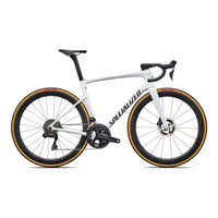 White road bike with aero frame, drop handlebars, disc brakes, and orange-rim tires