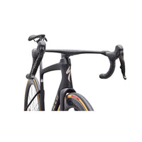 Carbon road bike with dark frame, black handlebars, and front fork