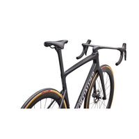 Road bike front view with matte black frame, curved drop bars, orange wheel trim