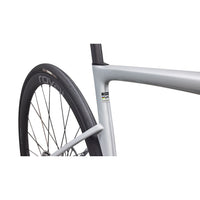 Silver road bike front fork and wheel with black tire, small frame label