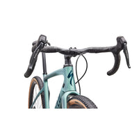 Teal gravel bike handlebar and top tube close-up with black brake hoods.