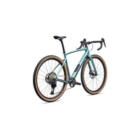 Teal gravel bike front three-quarter view with drop handlebars and tan sidewall tires.