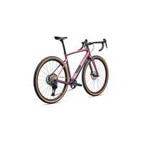 Gravel road bike with pink metallic frame, drop handlebars, disc brakes, tan tire trim