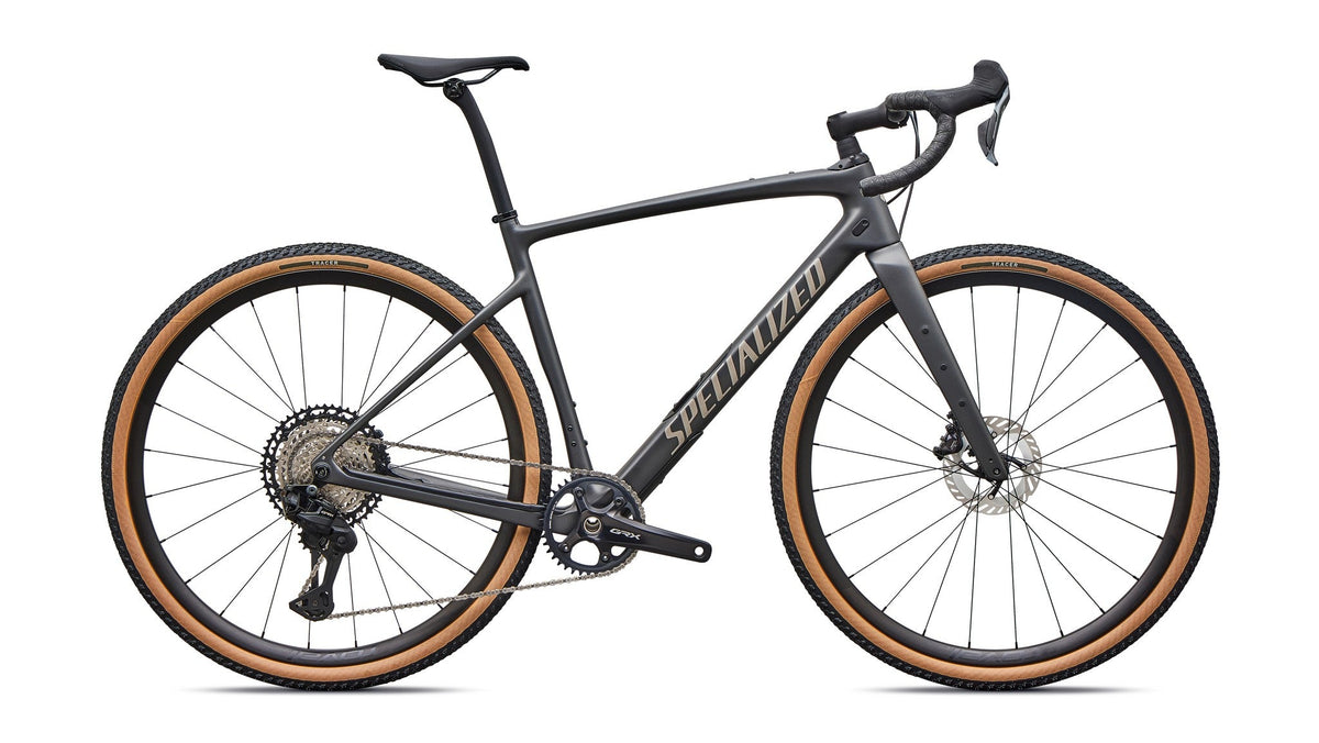 Gravel road bike side view: dark gray frame, drop bars, disc front wheel, tan trim