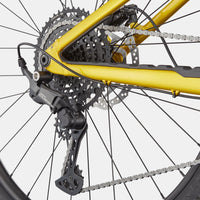 Yellow bike rear wheel with disc rotor, cassette, and knobby tire