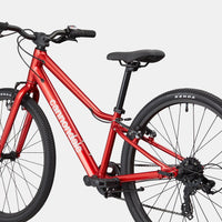 Kids red bike with black saddle, front headlamp, and knobby tires