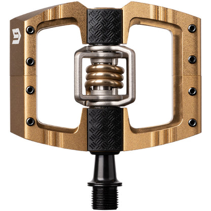 Bronze downhill bicycle pedal with black grip pads and spring center