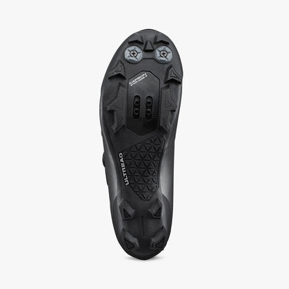 Black cycling shoe outsole with traction studs and vented plate