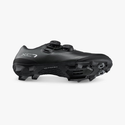 Black cycling shoe, heel and side view with BOA dials and cleat-ready sole