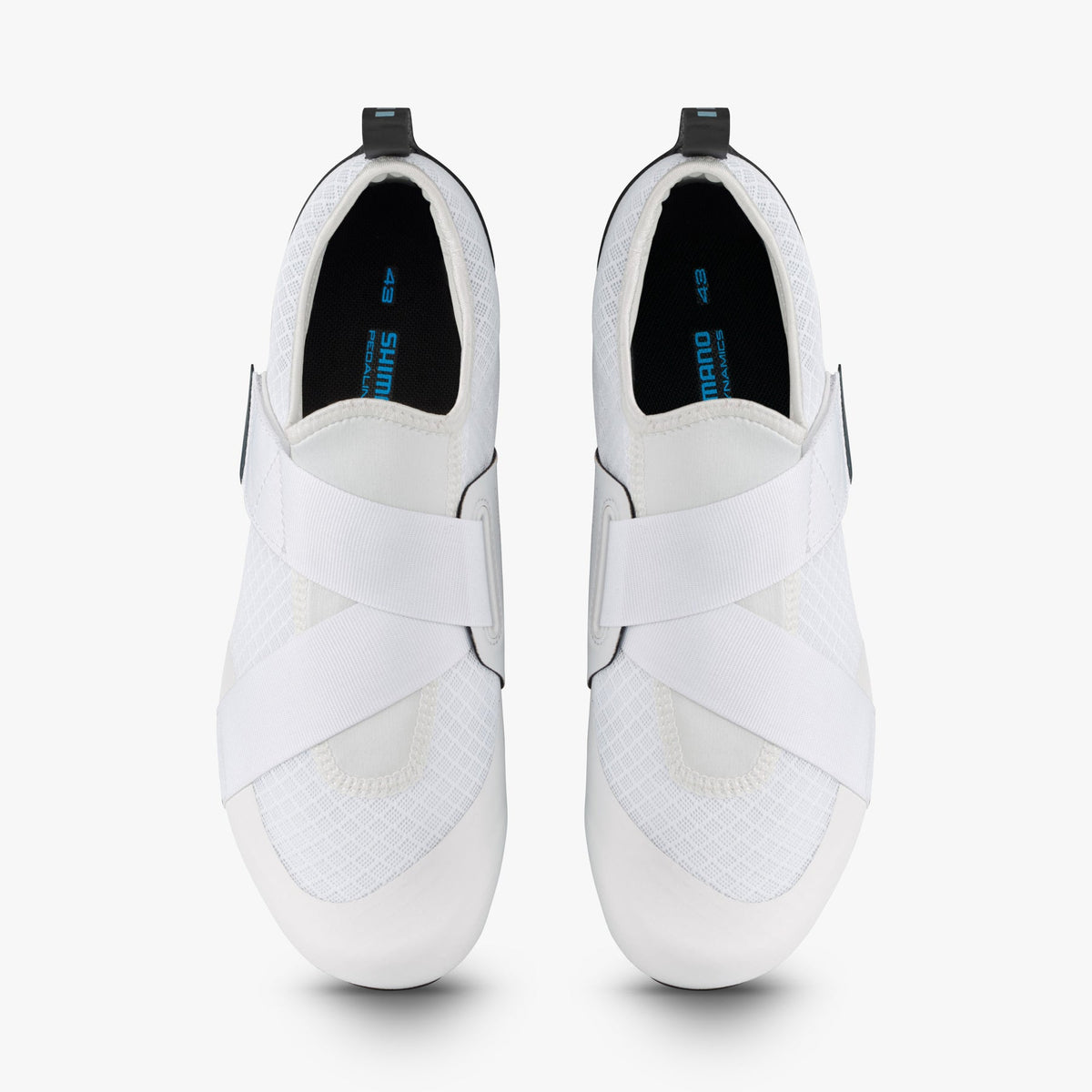 Top view of white Shimano women's cycling shoes with crossed straps and black insoles