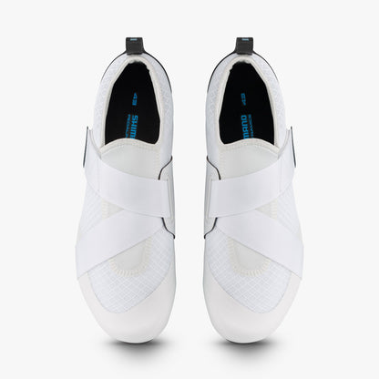 Top view of white Shimano women's cycling shoes with crossed straps and black insoles