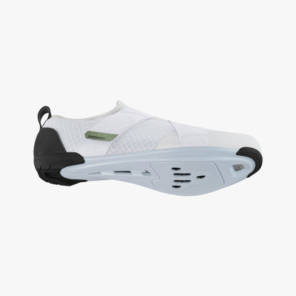 Bottom view of a white Shimano women's cycling shoe with cleat slots and black rubber tread