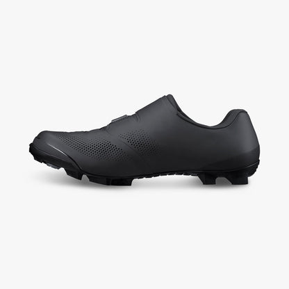 Black cycling cleat shoe, side view with studded outsole and smooth upper panel