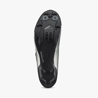 Silver cycling shoe outsole with black tread and cleat mounting pattern