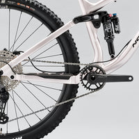 Rear drivetrain, crank, and chain on a white full-suspension mountain bike
