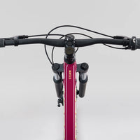 Front view of magenta 26 in mountain bike handlebars and suspension fork