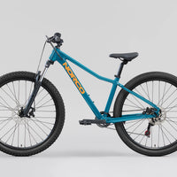 Teal 26 in mountain bike shown in side view, knobby tires and disc brakes
