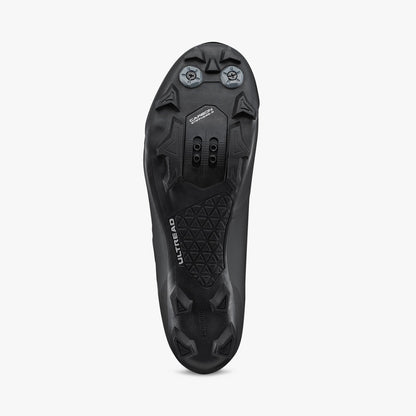 Black cycling shoe outsole with molded traction studs and cleat mounting points