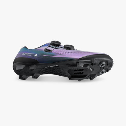 Iridescent purple cycling cleat shoe side view showing cleat plate and studs